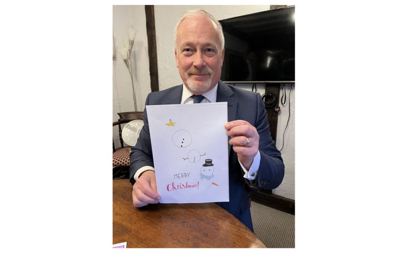 Richard holding the winning entry for his 2023 Christmas Card Competition 