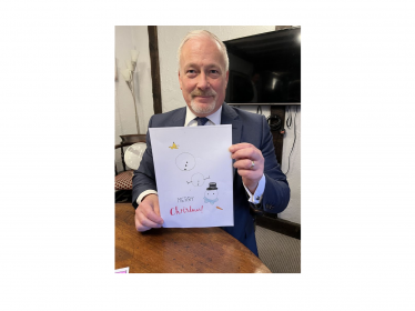 Richard holding the winning entry for his 2023 Christmas Card Competition 