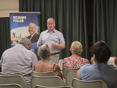 Richard addressing Roxton Town Hall meeting in July 2026