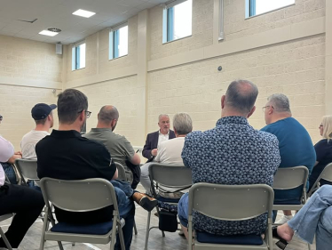 Photo of Richard speaking to residents at King's Reach Town Hall in Biggleswade July 2025